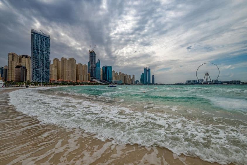 Zlé počasie v Dubaji s dažďom, silným vetrom a vlnami pri pobreží.