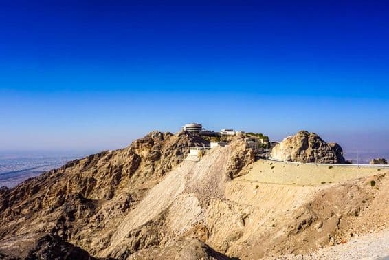Krajina pohoria Jebel Hafeet v Al Ain s vrcholmi a budovami.
