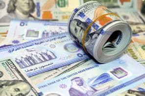 100 dolárové americké bankovky a dirhamy.