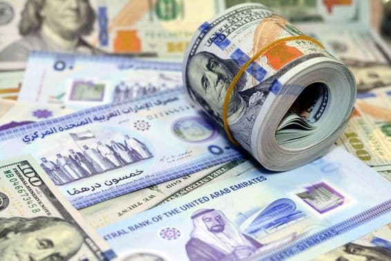 100 dolárové americké bankovky a dirhamy.