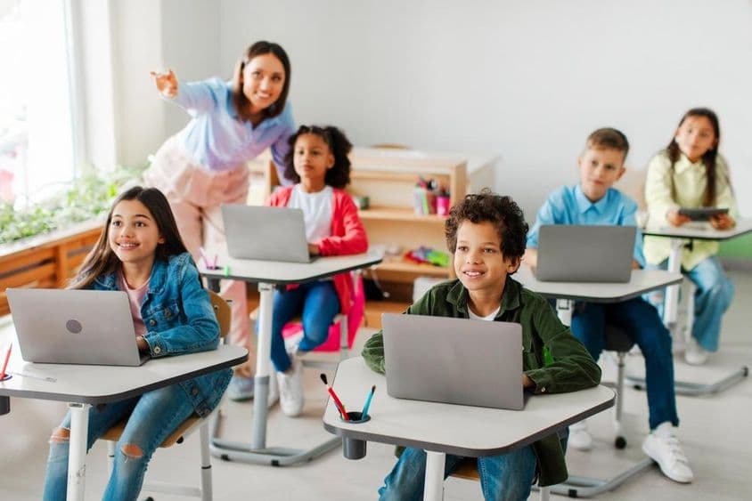 Školáci používajúci laptopy počas hodiny.