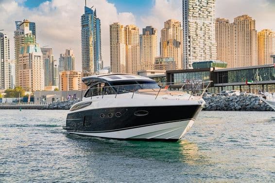 Luxusná jachta v Dubaji s panorámou a mrakodrapmi.