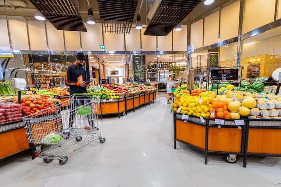 Kuriér vyberajúci zeleninu a ovocie v supermarkete.