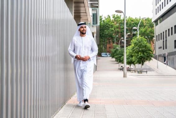 Arabský moslimský podnikateľ kráčajúci v obchodnej štvrti mesta.