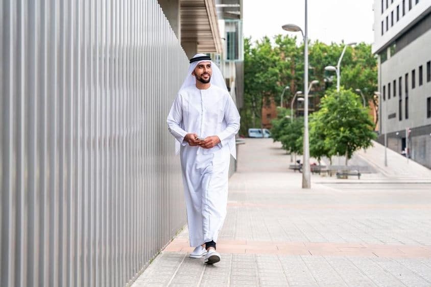 Arabský moslimský podnikateľ kráčajúci v obchodnej štvrti mesta.