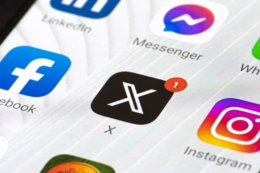 Logo Twitter alebo X s počiatočným písmenom a aplikáciou na smartfóne.