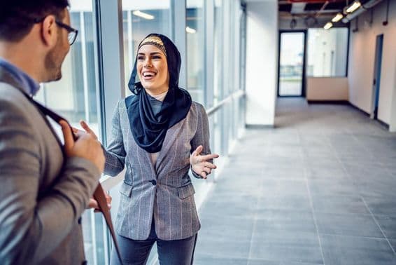 Usmievavá atraktívna Arabka diskutuje o budove s realitným agentom.