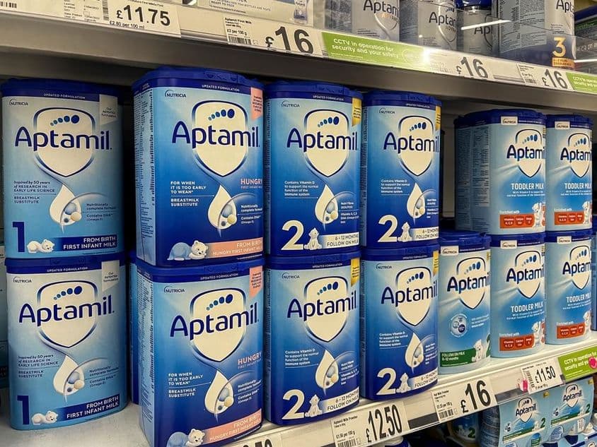 Aptamil mliečny prášok na regáloch supermarketov.