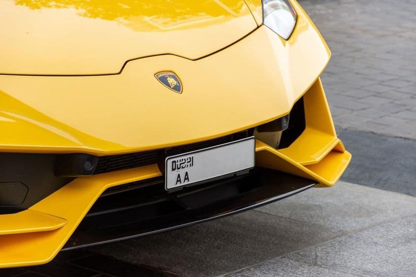 Detailný záber na logo Lamborghini na prednej časti auta.