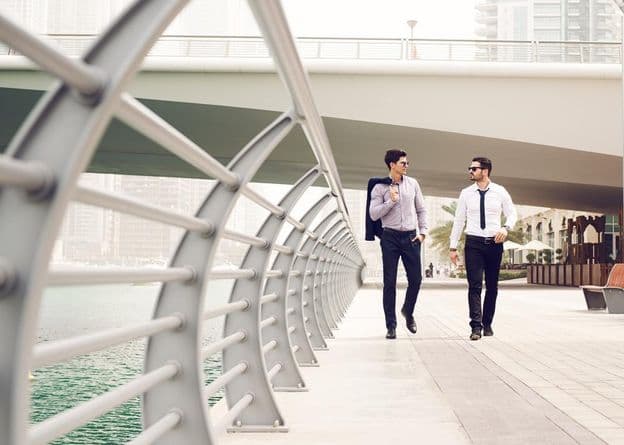 Podnikatelia kráčajúci po dubajskej marine.