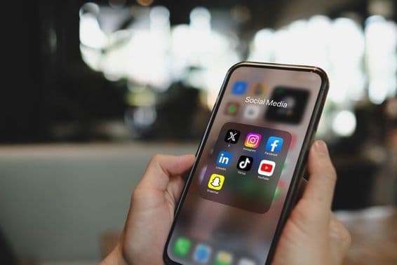 Obrazovka iPhone 15 Pro s ikonami aplikácií sociálnych médií.