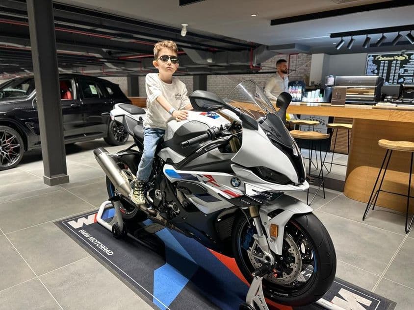 Chlapec s okuliarmi na motocykli BMW.