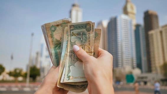 Mena Spojených arabských emirátov na pozadí dubajských mrakodrapov.