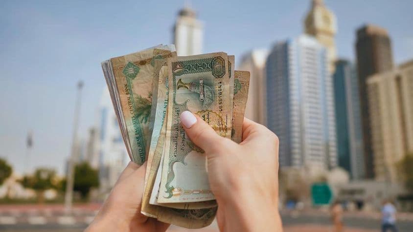 Mena Spojených arabských emirátov na pozadí dubajských mrakodrapov.