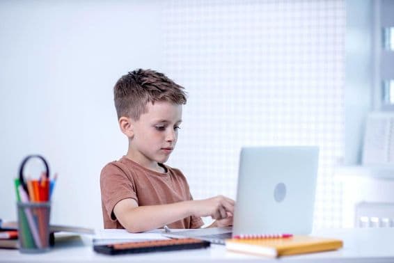 Školák hovorí s učiteľom cez videokonferenciu na počítači