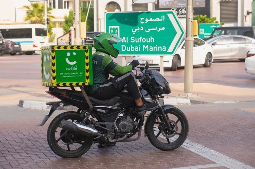 Motocyklista z ekologickej zelenej doručovacej služby Careem.