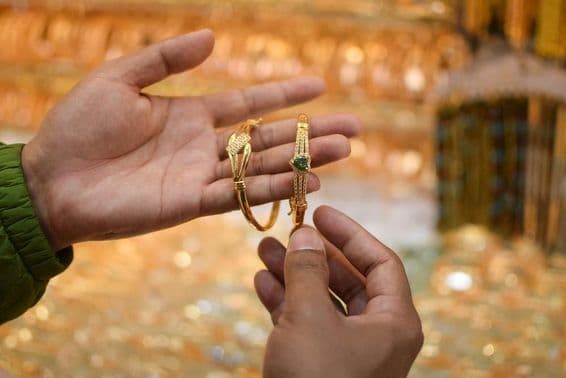 Ruka skúšajúca luxusný zlatý náramok