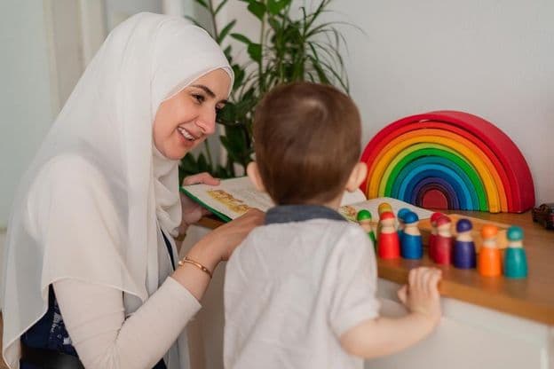 Učiteľ moslim a predškolák hrajúci sa s farebnými hračkami
