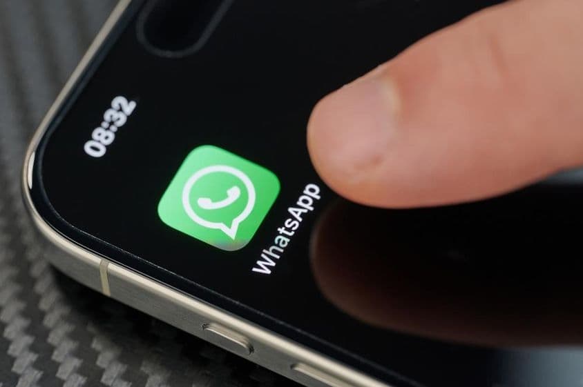 Prst dotýkajúci sa ikony aplikácie WhatsApp