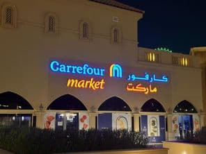 Osvetlené logo Carrefour market s arabským názvom značky