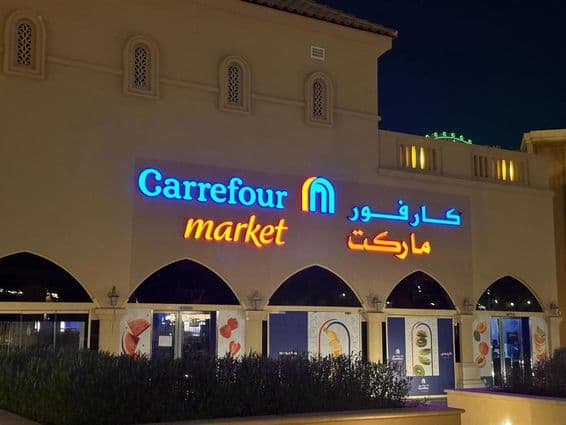 Osvetlené logo Carrefour market s arabským názvom značky