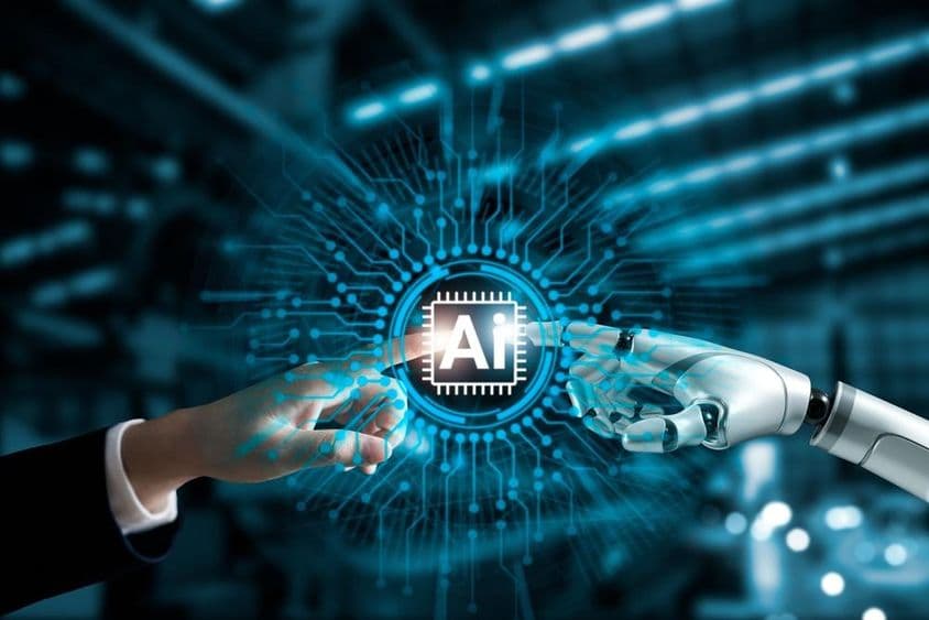 Robot a ľudské ruky spájajúce AI obvod.