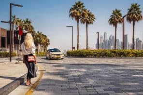 Žena stojí na ulici a čaká na taxi.