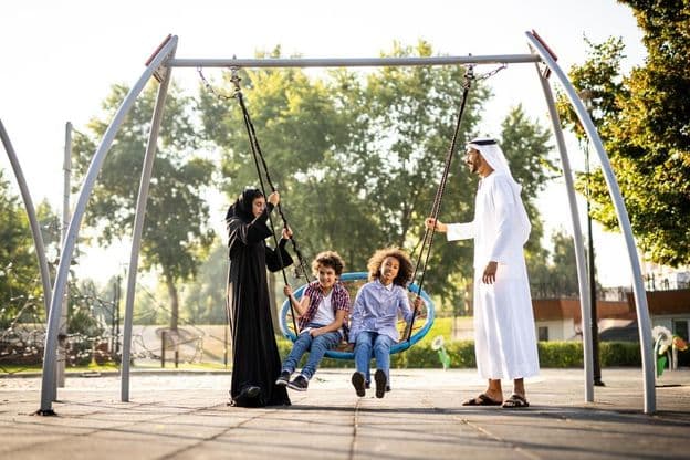 rodina hrajúca sa na ihrisku v Dubaji